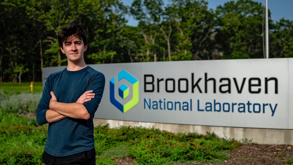Edward Jansen standing in front of the Brookhaven National Labs sign