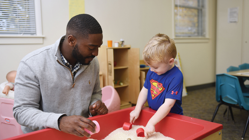 An Adelphi student works closely with a young child in the Early Learning Center