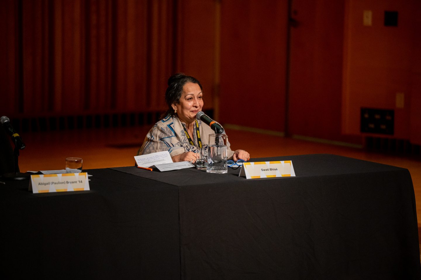 Women sitting at a table with a microphone.