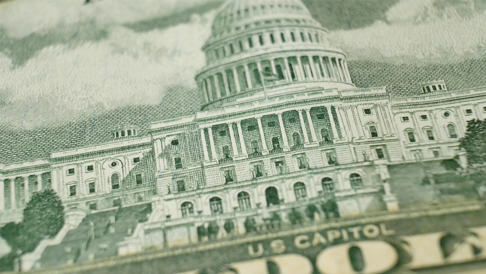 A detail from the back of a $50 bill, showing the United States Capitol.