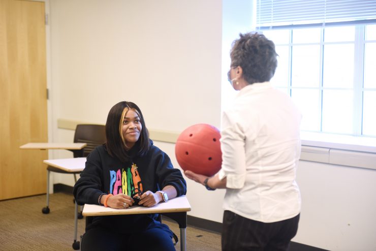 Health sciences classroom at Adelphi. Professor holding ball while lecturing.