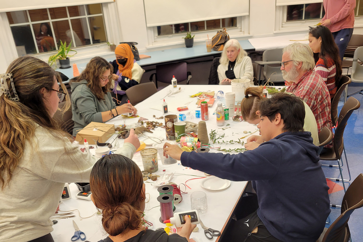 Guest artist Trebbe Johnson (seated, center) and John McDermott, associate professor of theater (right) with students creating the mandala.