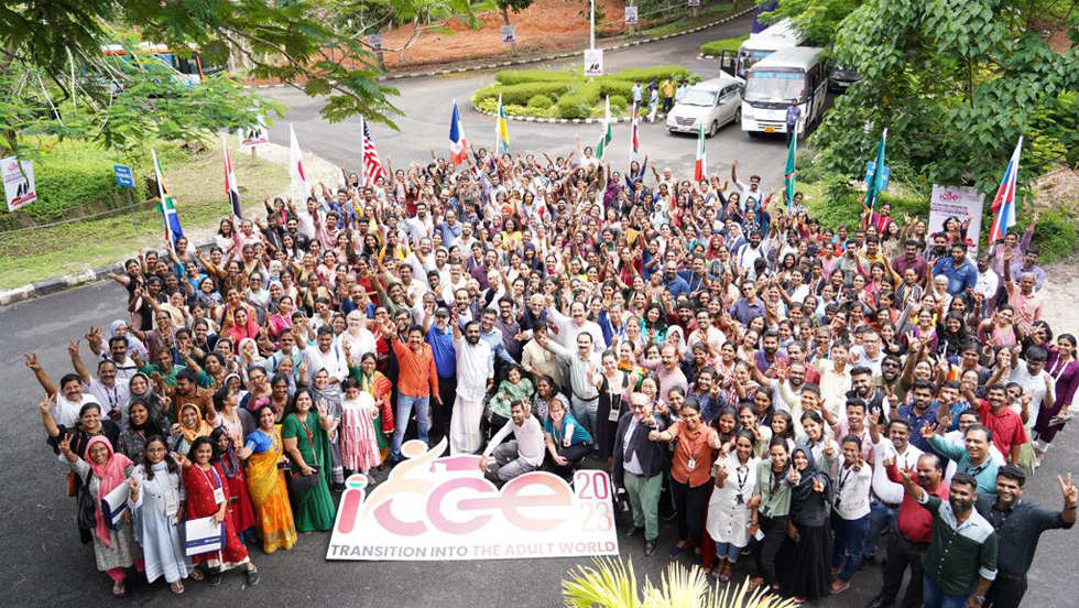 A crowd of people is outside, standing next to the logo that reads "ICCE 2023, Transition Into the Adult World."