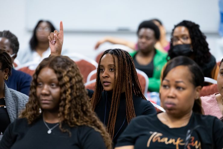 Adelphi Social Work student raises hand in class.