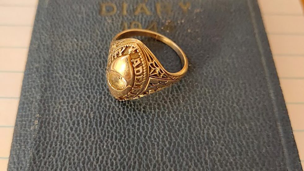 gold Adelphi class ring lying on a book