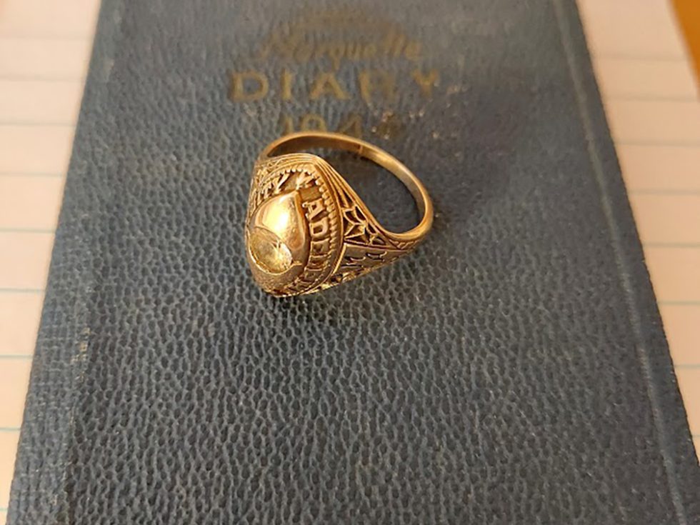 gold Adelphi class ring lying on a book