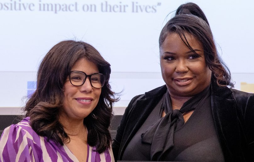 Monika Goodwin-Ghee and Sandra Castro stand next to one another, both smiling for the camera.