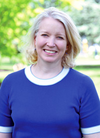 Photo of Andrea Ward, who is standing outside with trees in the background.