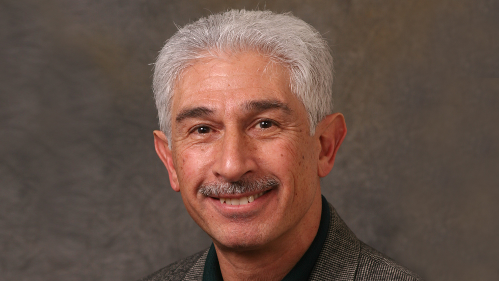 Middle-aged white man, gray hair and mustache, smiling.