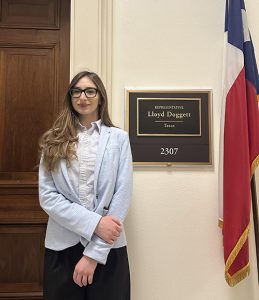 Burjanadze stands next to the door of Rep. Doggett's office. A plaque beside her says "Representative Lloyd Doggett, Texas." Next to it is the flag of the State of Texas.