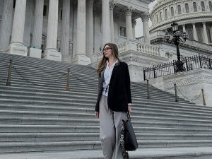 Nino on the stairs of the Capitol, facing away from the camera and holding a briefcase.