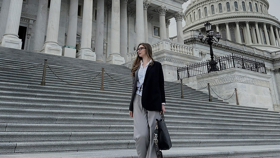 Nino on the stairs of the Capitol, facing away from the camera and holding a briefcase.