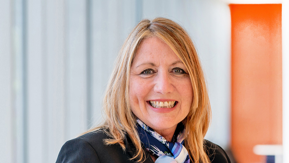 A woman faces the camera, smiling