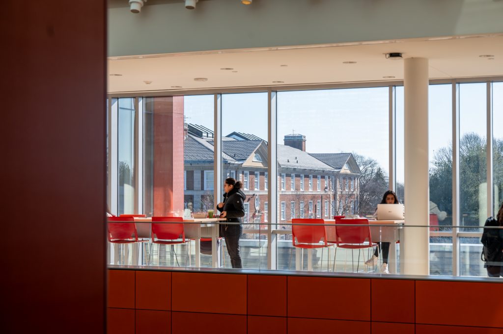 A view of the second floor of the Adelphi University Nexus Building where people work on laptops and learn.