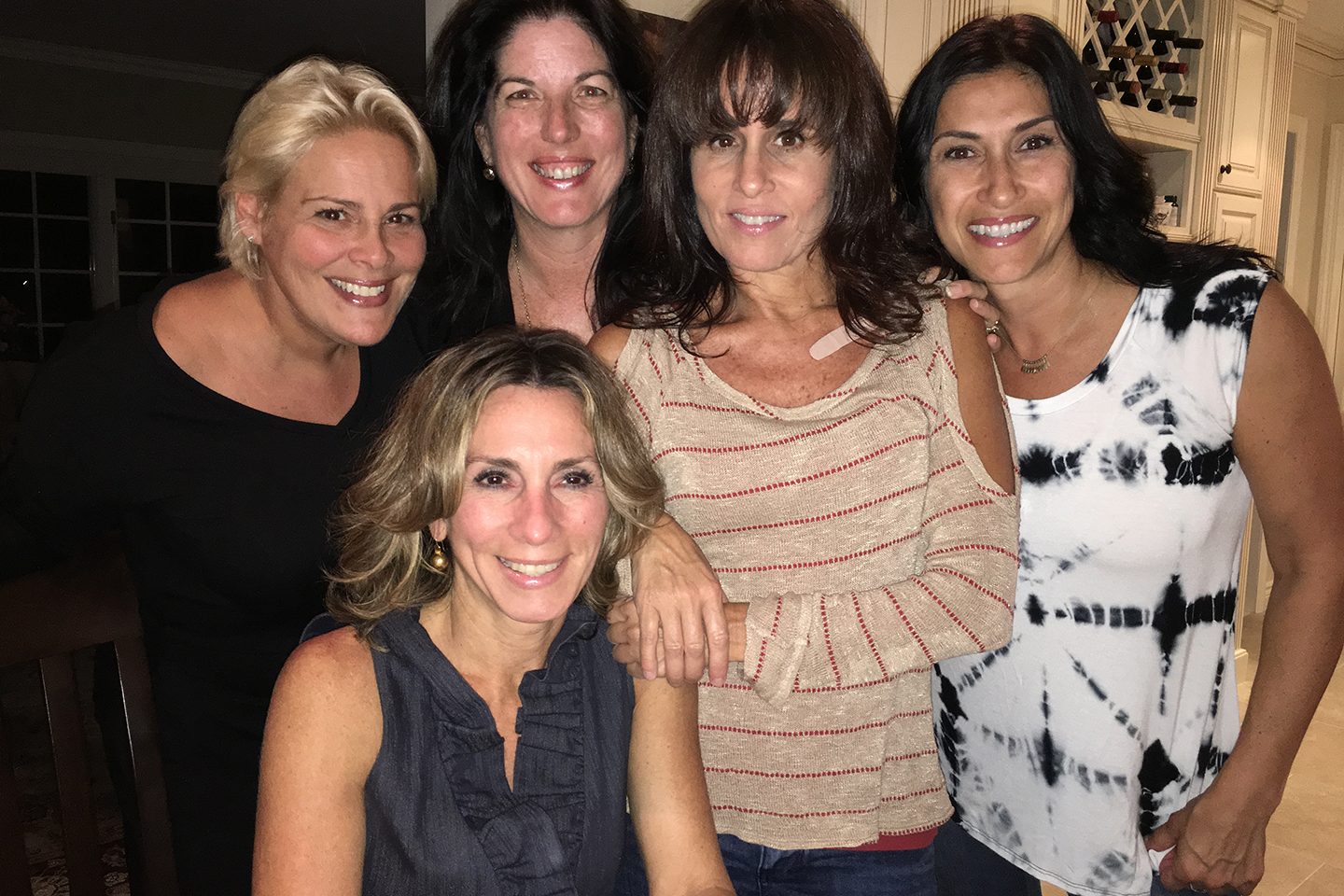 Five women together facing forward, all smiling
