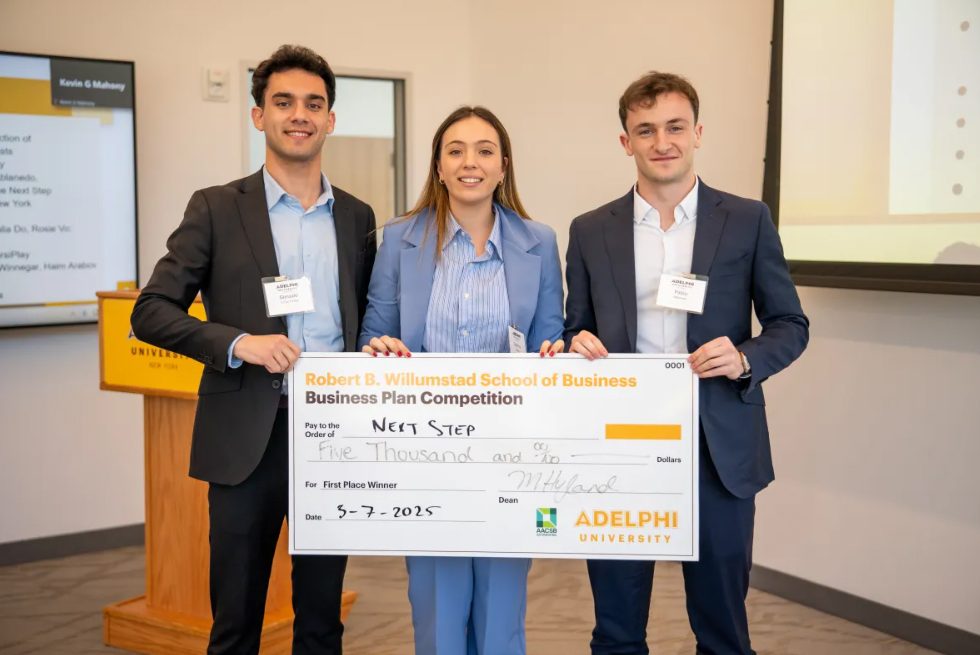 Three students holding up a oversized check.