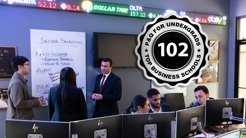 Business students is a simulated trading room featuring tickers and computers; Poets&Quants 2025 Best Undergraduate School badge is superimposed on the photo.