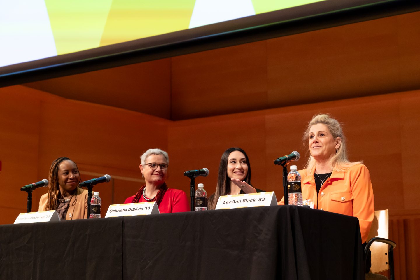 Conference Co-Chair Lee Ann Black '83 shares the stage with three panelists.