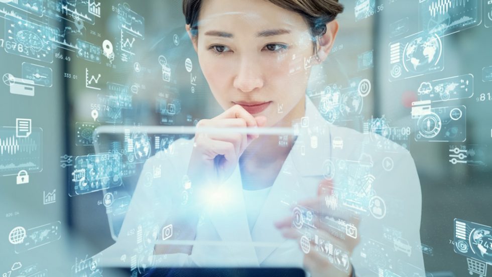 Woman in a medical professional's white jacket looks at a semi-transparent tablet surrounded by technology symbols.