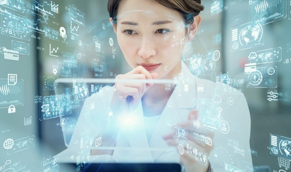 Woman in a medical professional's white jacket looks at a semi-transparent tablet surrounded by technology symbols.