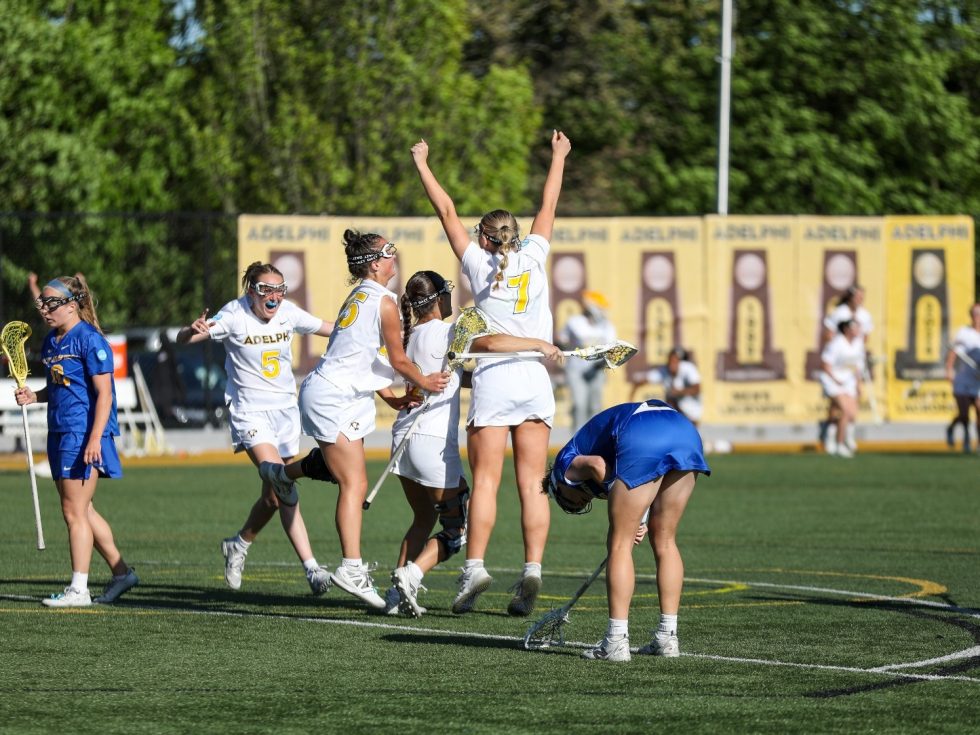 Women&#039;s Adelphi lacrosse players on the field.