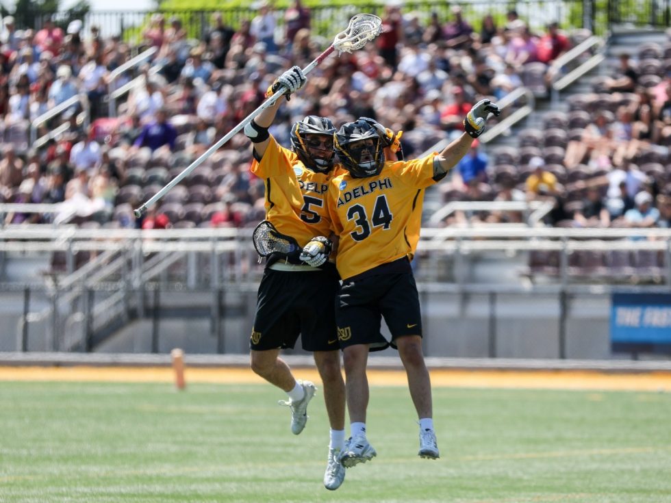Men&#039;s lacrosse players celebrating on the field.