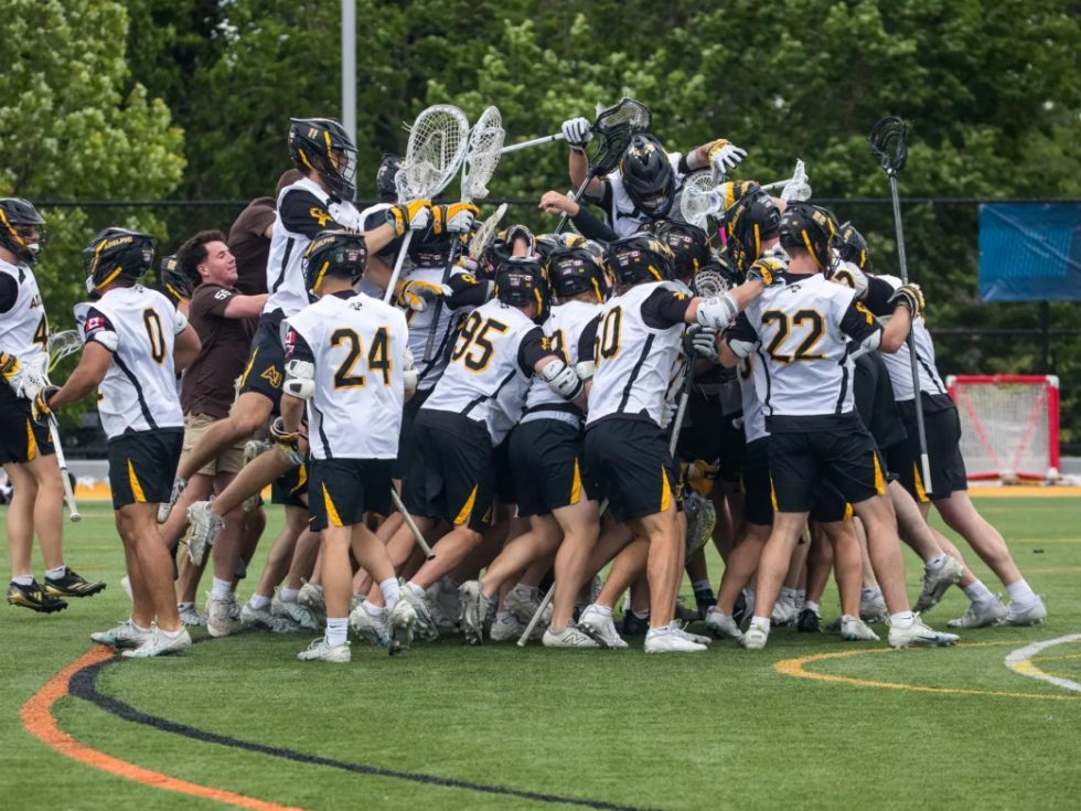 Men's Lacrosse team celebrating on the field.