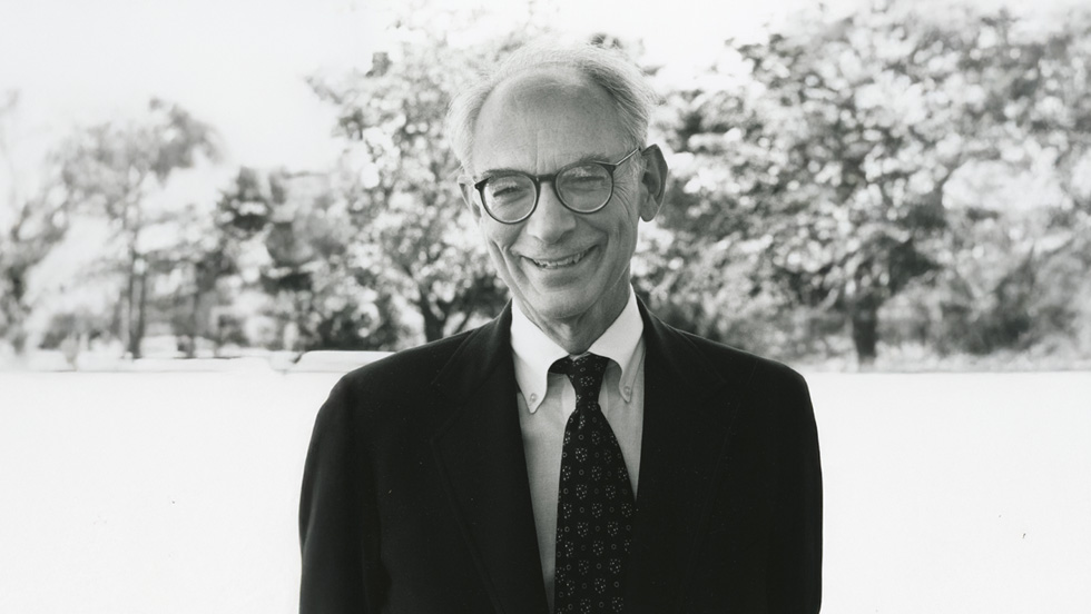 Black and white photo of a smiling, kindly professor Lou Starkey, PhD