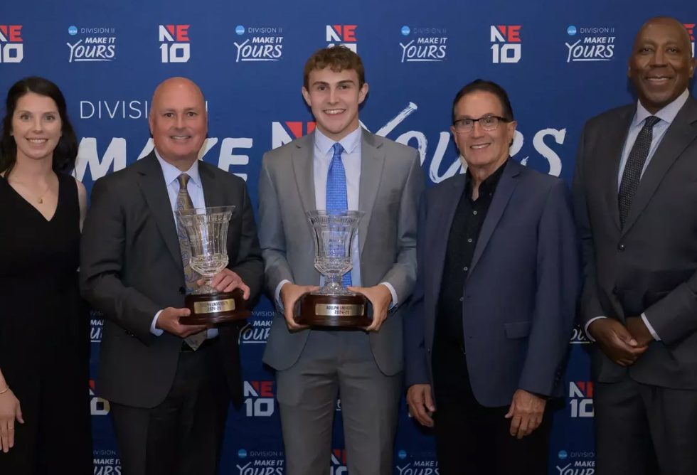 One woman and Four Men. Two are holdign trophies