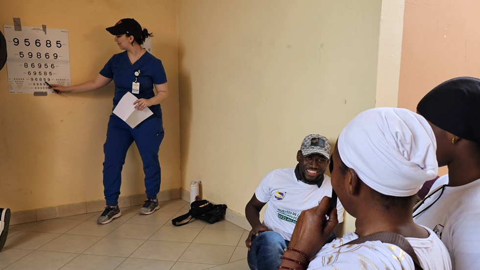 Medical student Anastasia Dakis stands at an eye chart, testing local citizens.