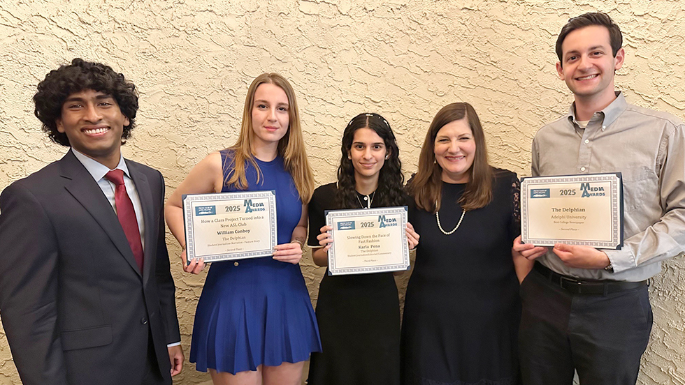 Five people posing together, four holding certificates and smiling at the camera, dressed in formal or semiformal attire.