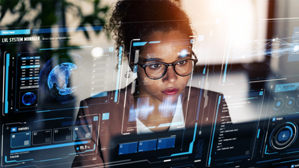 A photo illustration of a young woman sitting before a computer with a system manager's dashboard shown as in a heads-up display.