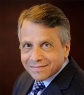 headshot profile image of brown-haired man in a suit and tie