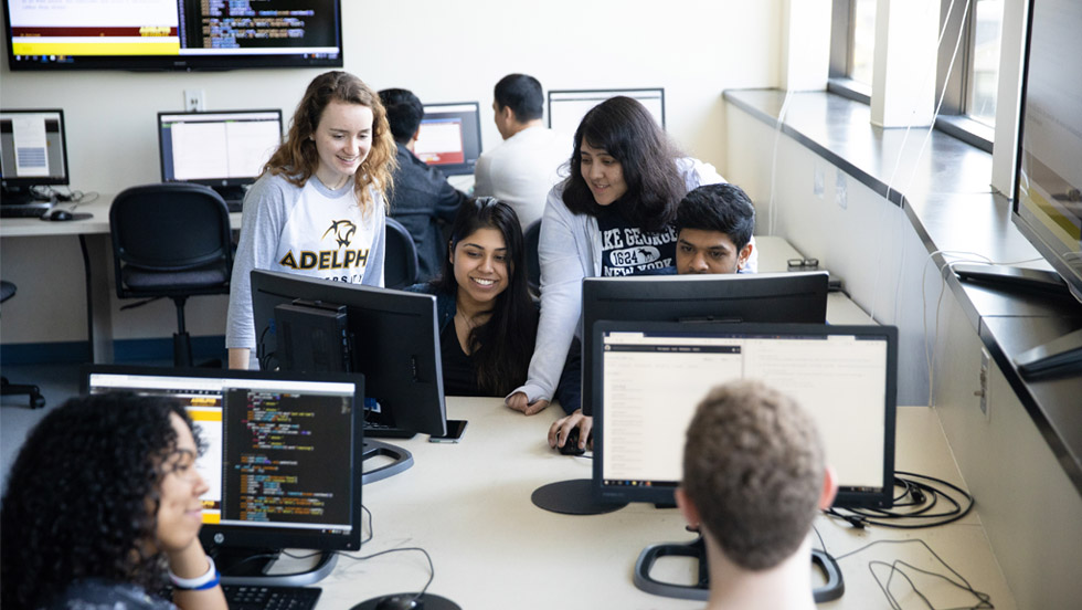 Eight Adelphi students gather around their computer screens, talking excitedly.