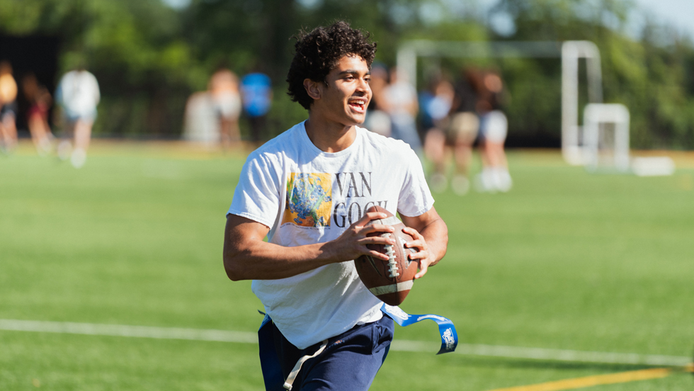 A quarterback runs while getting ready to pass the ball.