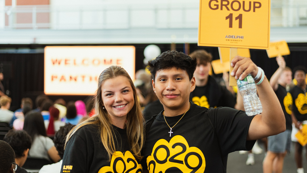 Two students wearing Class of '29 T-shirts hold up a yellow sign saying "Group 11."