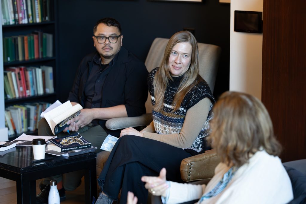 Three people sitting at a table talking