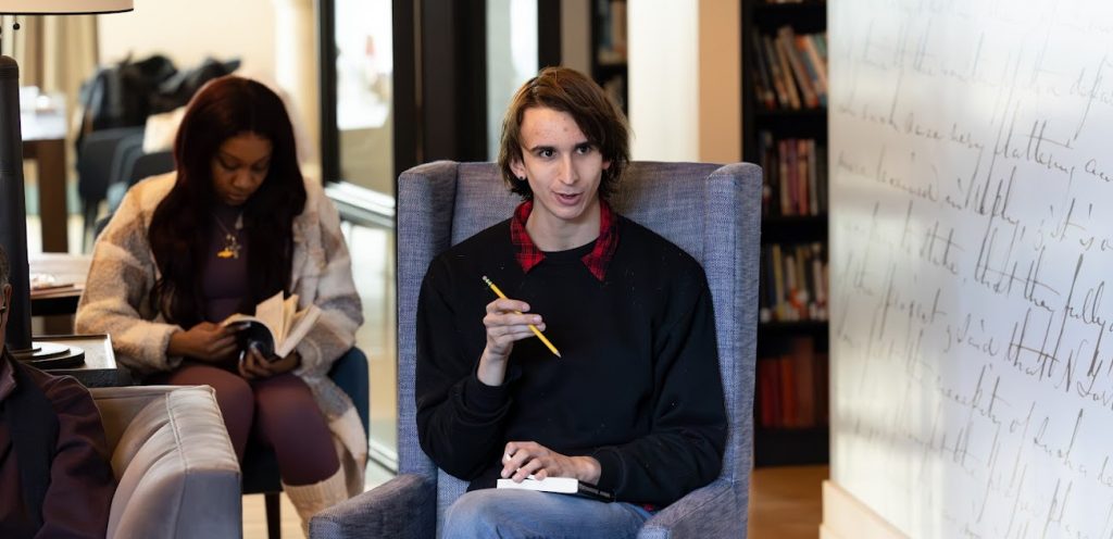 A MFA student sitting in a chair speaking