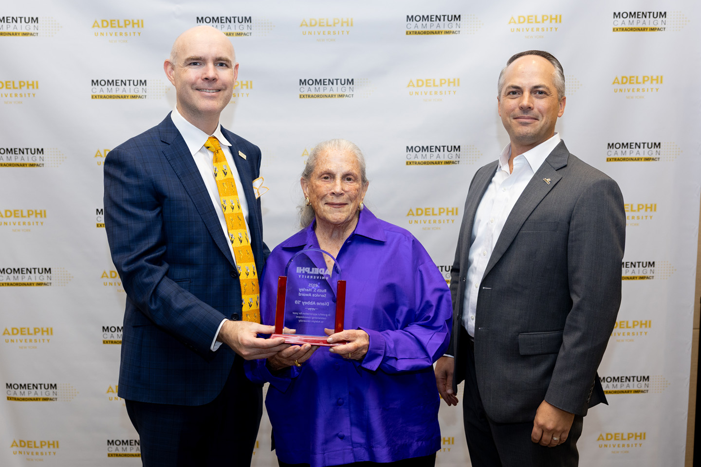 Diane Abbey holds the award plaque, with Dr. Storm on her right and Dr. Kline at her left.