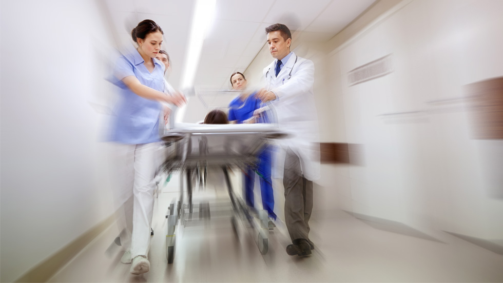A blurred motion image of medical professionals pushing a stretcher in a hospital corridor