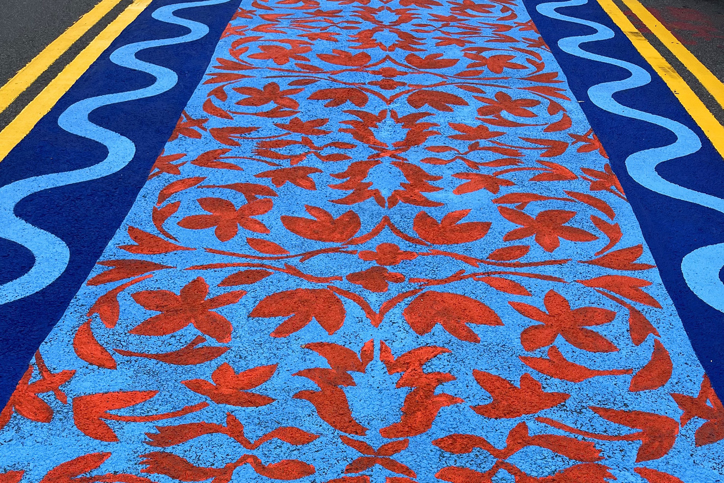 A close look at one of the carpets, showing red leaf designs on a blue background