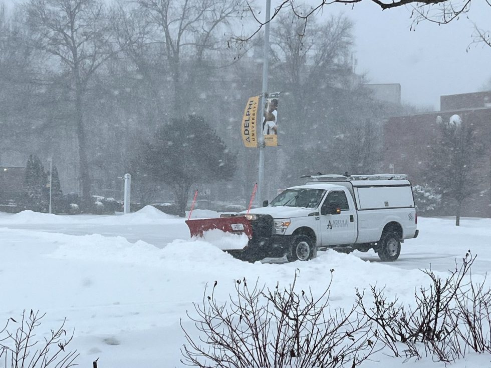 Adelphi University campus with snow plowing the parking lots.