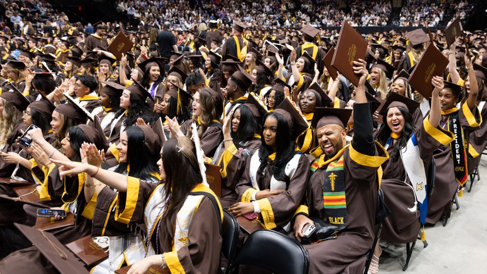 Students wearing Adelphi graduation attire celebrate their graduation at Commencement ceremonies 
