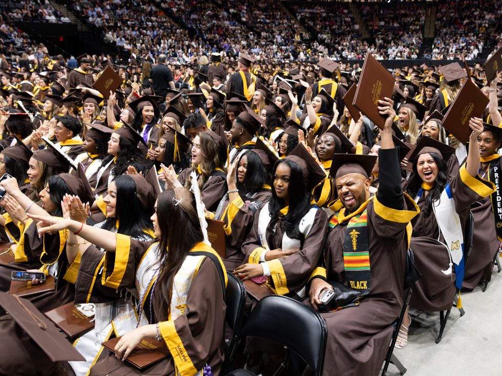 Students wearing Adelphi graduation attire celebrate their graduation at Commencement ceremonies 