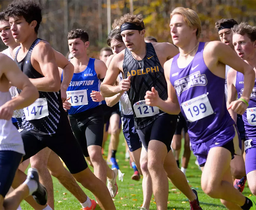 Several young men run together, wearing uniforms and race numbers.