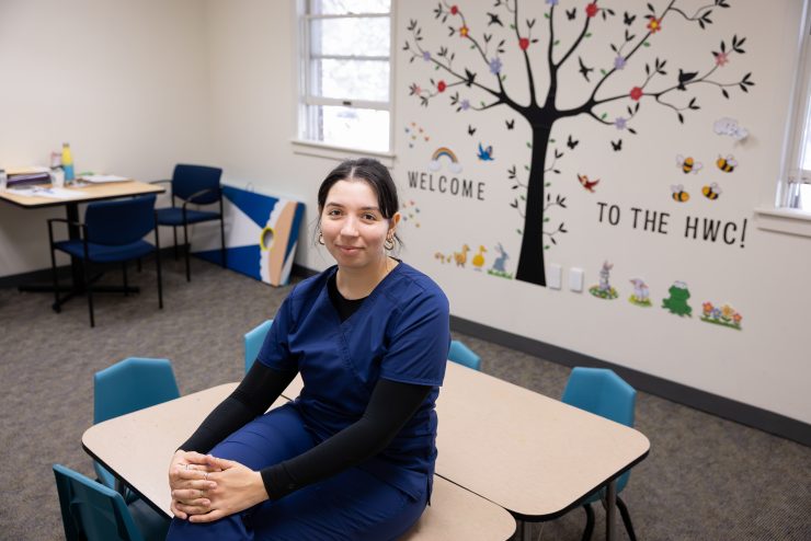 Adelphi SLP student wearing scrubs in the Hy Weinberg Center for Communication Disorders.