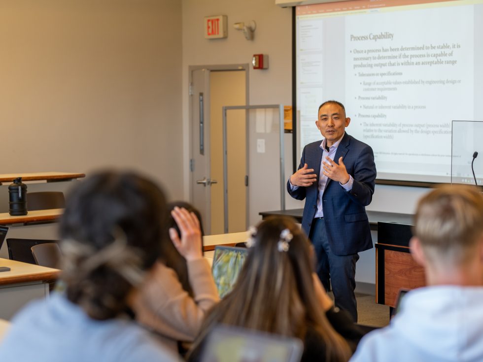 Professor Zhang teaching a classroom setting speaking to a group of students 