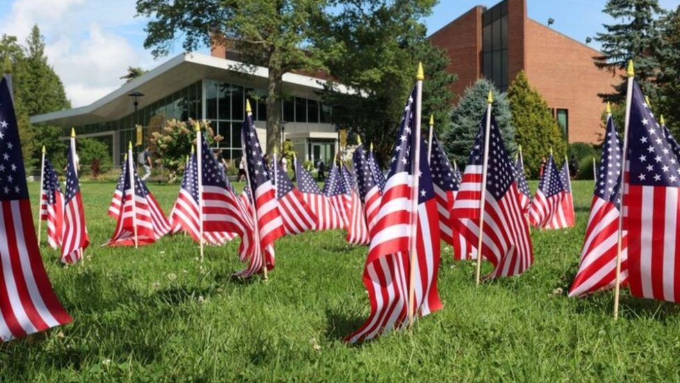 Adelphi University Center with a lawn full of American Flags as a memorial