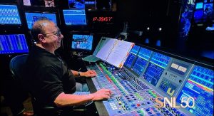 Palladino sits at the sound board laughing at one of the show's jokes.