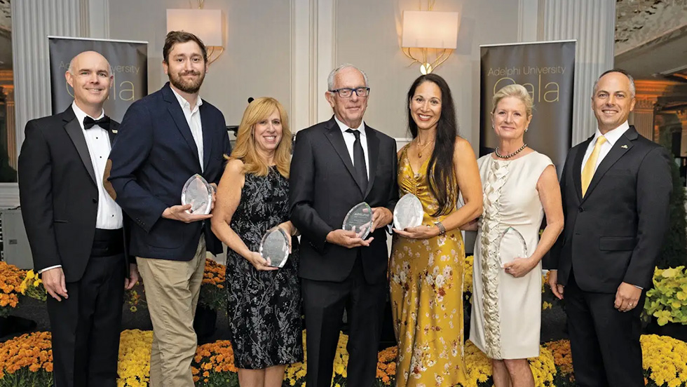 A group of people dressed formally and smiling in an event space.